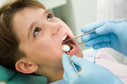 little boy opening his mouth during dental checkup